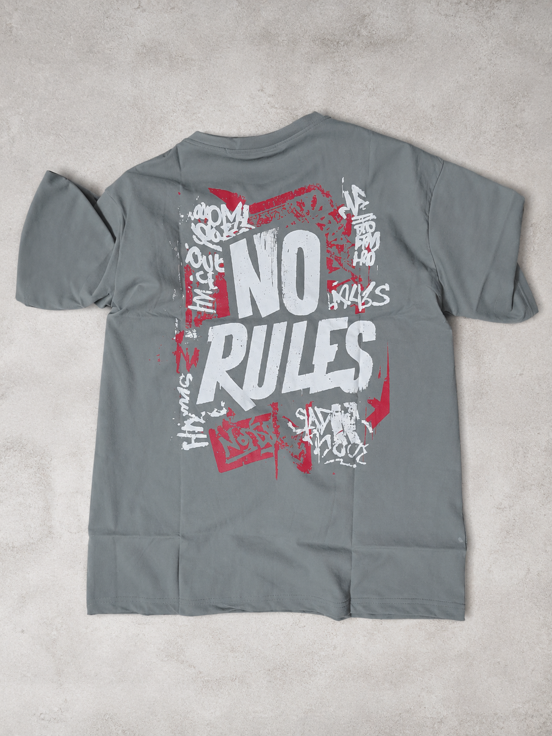 A gray pullover hoodie laid flat on a textured light gray surface, featuring a large front graphic with the words 'NO RULES' in white and red graffiti-style lettering.